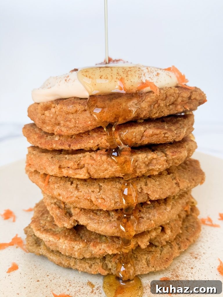 stack of healthy carrot cake pancakes with a maple syrup pour