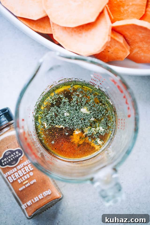 Overhead view of sauce and seasonings in a liquid measuring cup for Sweet Potato Roast with Parsley Pesto