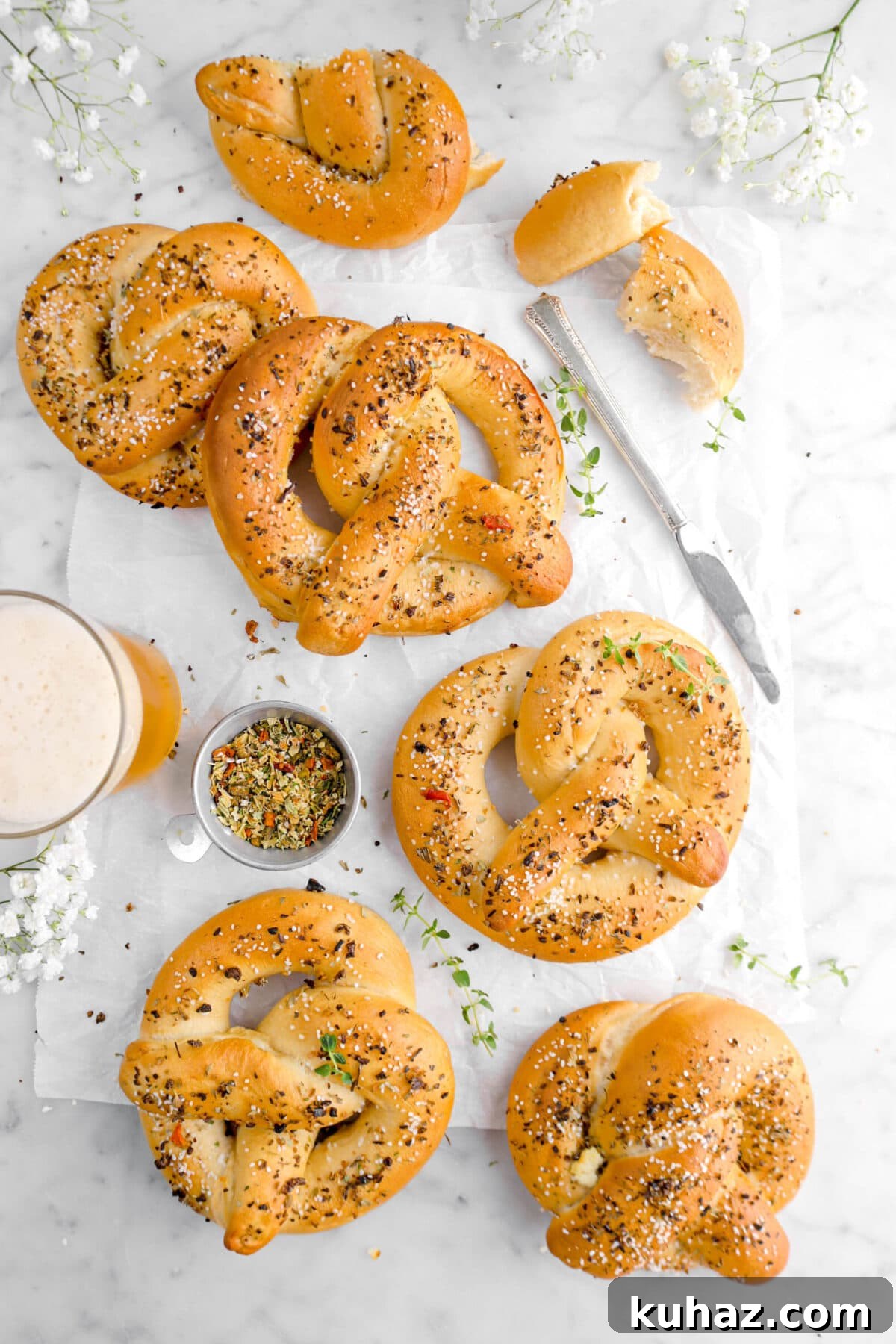 Giant Goat Cheese Stuffed Soft Pretzels 2 overhead shot of pretzels with thyme sprigs, white flowers, glass of beer, and a knife beside.