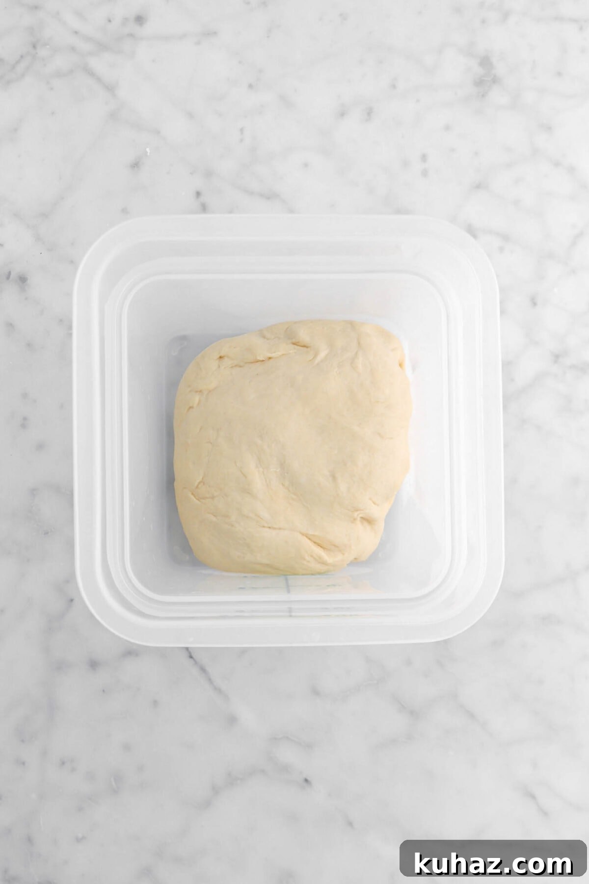 Giant Goat Cheese Stuffed Soft Pretzels 11 dough in plastic container on marble surface.