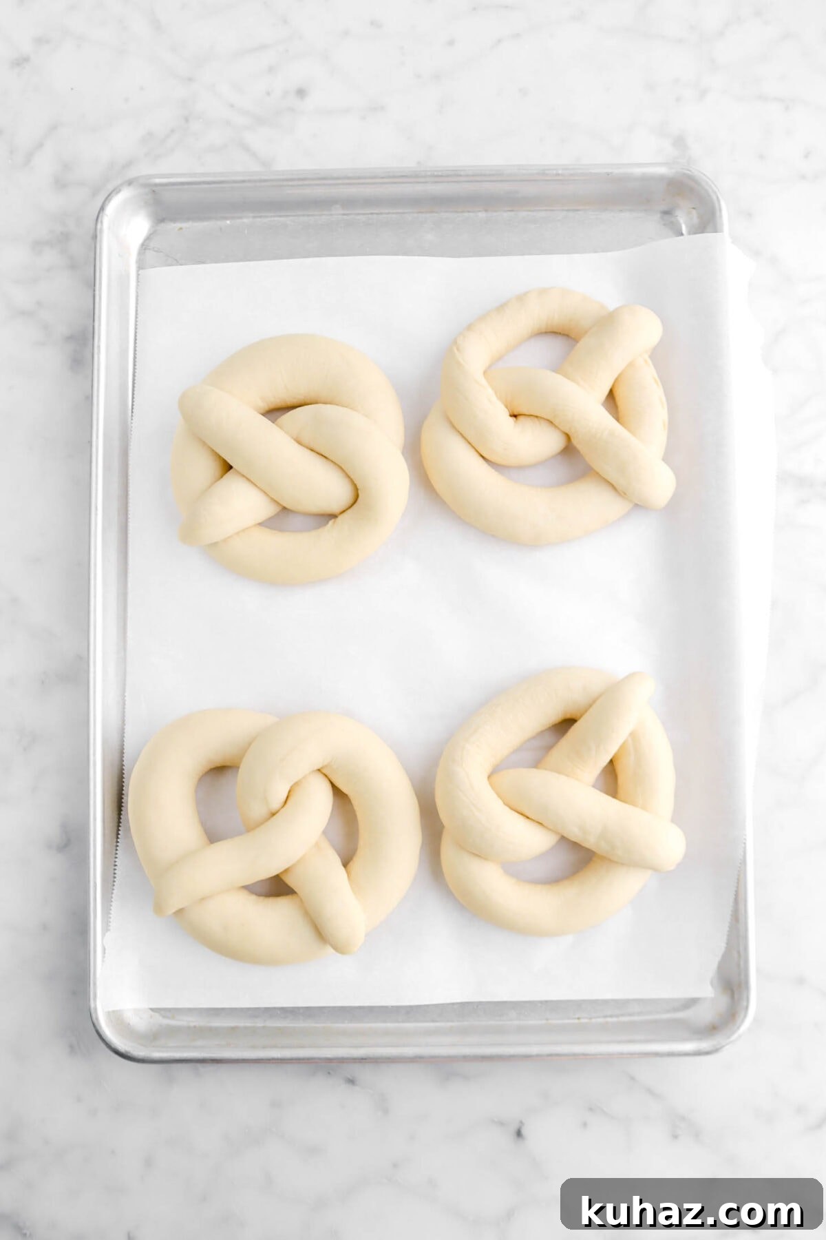 Giant Goat Cheese Stuffed Soft Pretzels 20 proofed pretzels on lined sheet pan.