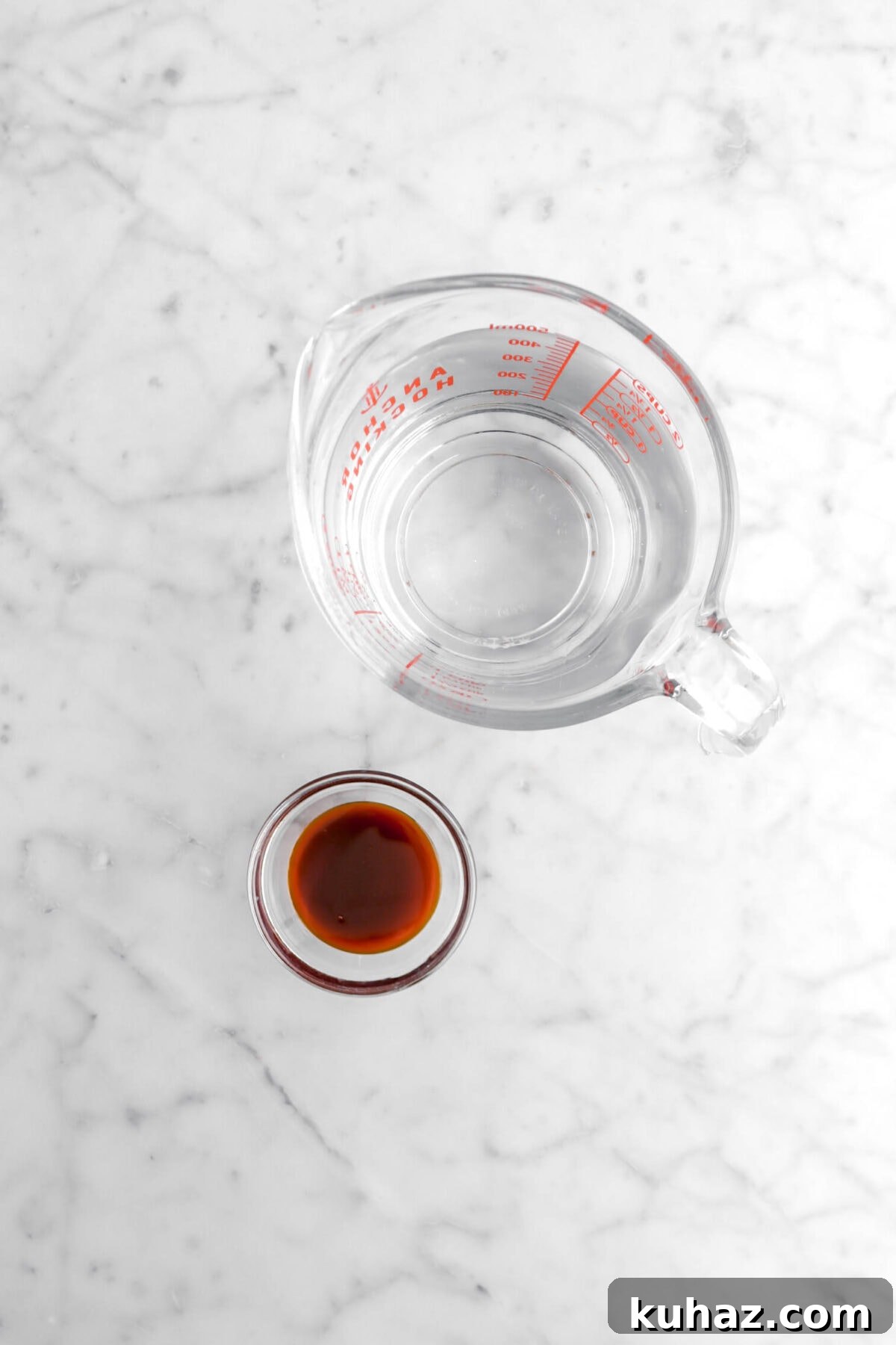 Giant Goat Cheese Stuffed Soft Pretzels 8 measuring cup of water and malt syrup in glass bowl on marble surface