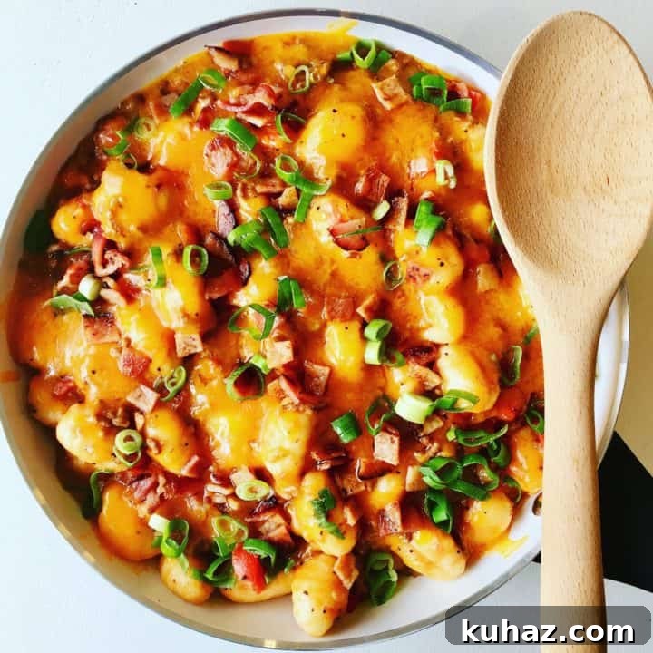 Family dinner gnocchi in a large white bowl with wooden spoon resting on it.