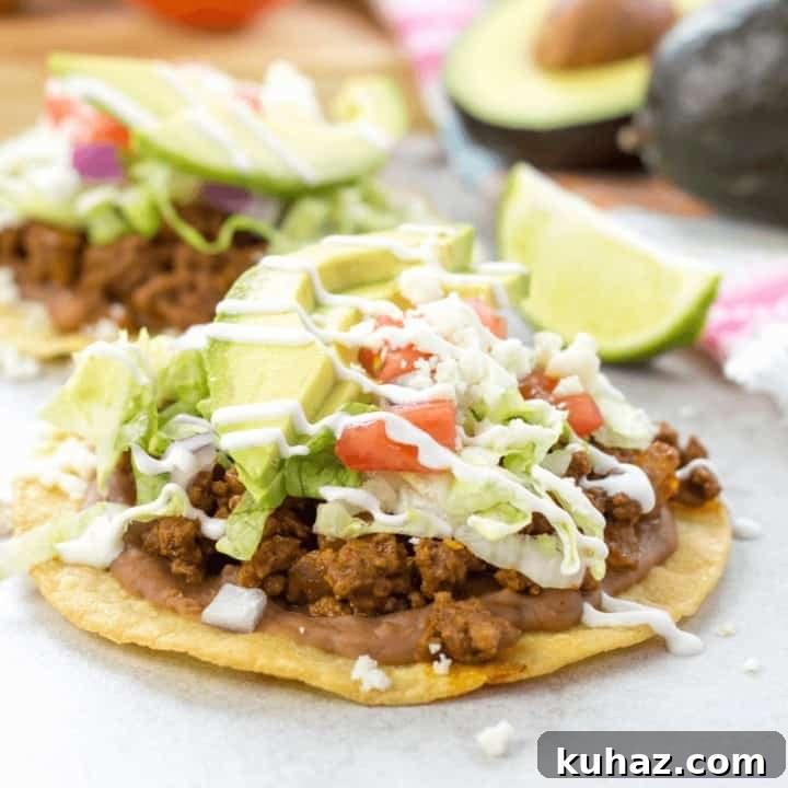 Beef Tostada on a white counter with one blurred in the background.