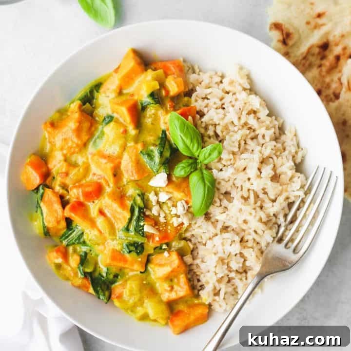 Curry recipe on a white plate with rice and a silver fork on it all on a white counter.