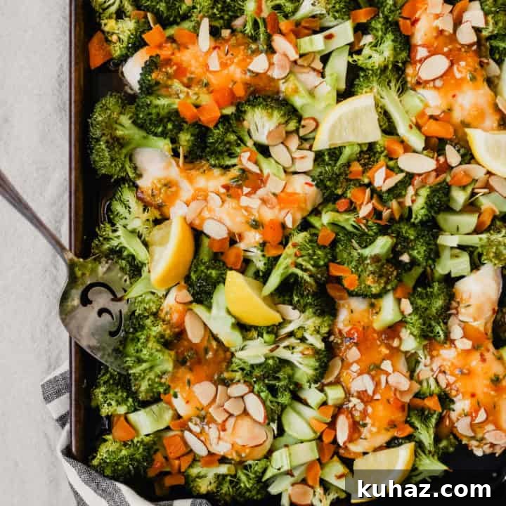 Broccoli and chicken sheet pan family dinner recipe on a naking dish with silver serving spoon.