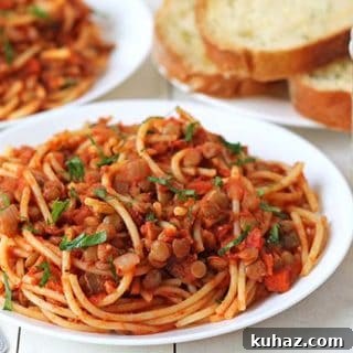 Vegan pasta on a white plate with a second one in the background blurred out.