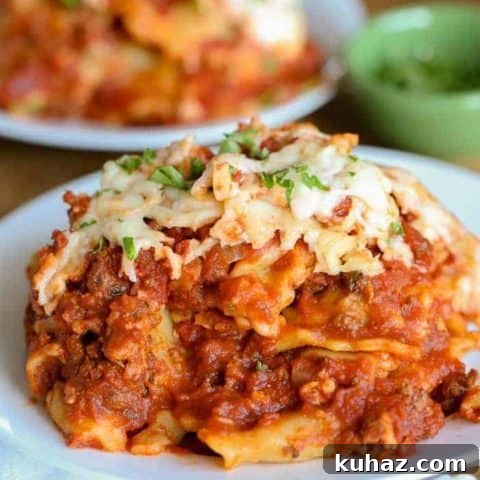 Crockpot lasagna on a white plate with second blurred out in the background.