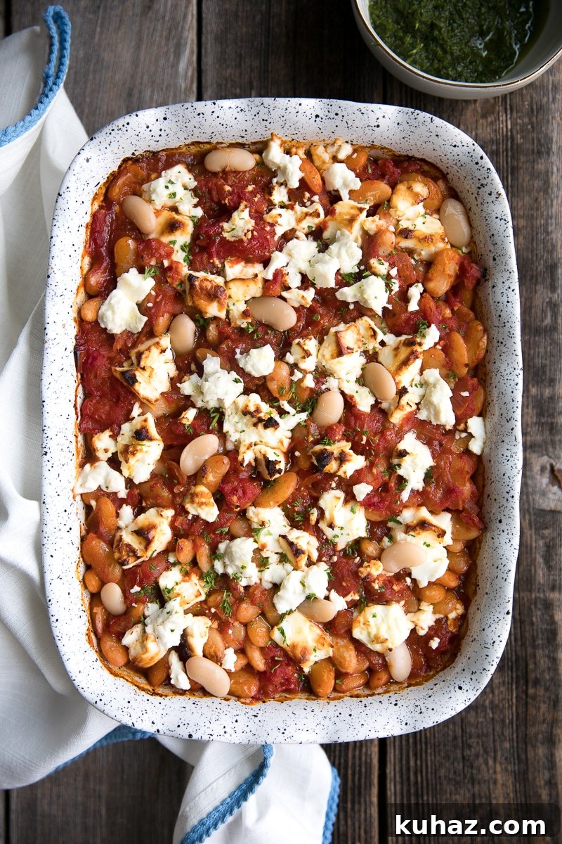 Vegetarian Baked Tomato Beans with Tangy Feta 3 Baked white beans and tomatoes with feta in a baking dish, ready to serve.