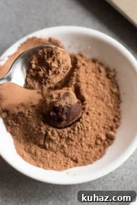 Homemade Chocolate Hazelnut Rum Truffles Recipe 16 spooning cacao powder over a rum truffle