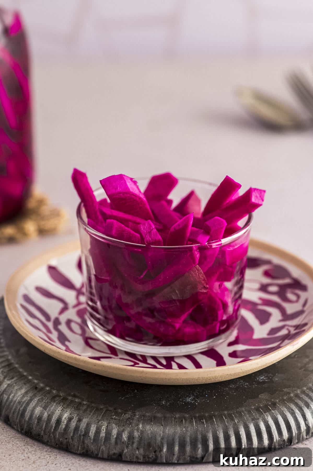 CLose up view of a glass bowl with pink turnip pickles