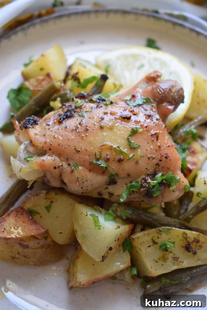 Sheet Pan Lemon Herb Chicken with Roasted Vegetables 10 Lemon chicken on a plate.