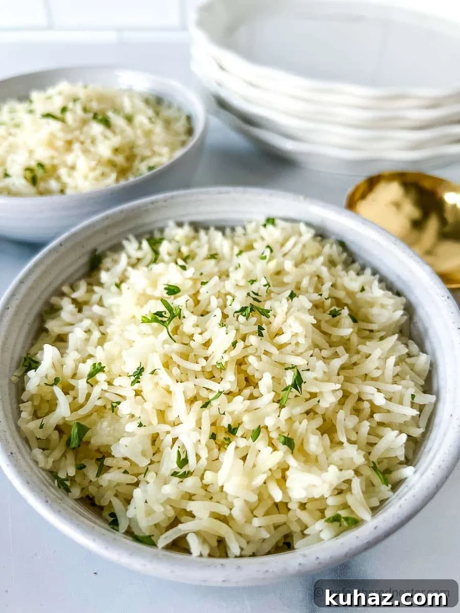 How to Make Fluffy Basmati Rice in an Instant Pot 6 Two white bowls of Instant Pot Basmati Rice with a stack of white plates and golden serving spoon at the background.