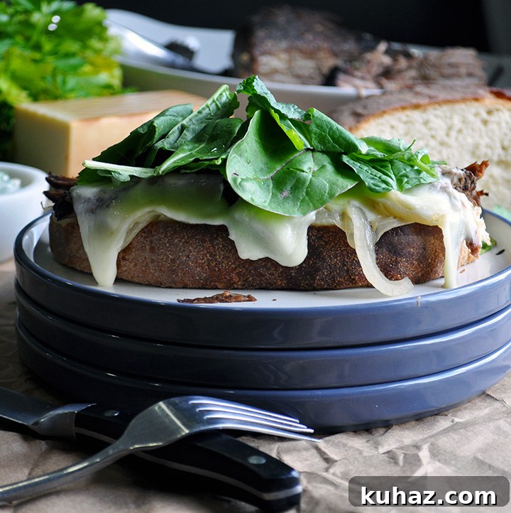 Shredded Pot Roast Sandwiches with Au Jus 2 An open face Pot roast sandwich on a plate