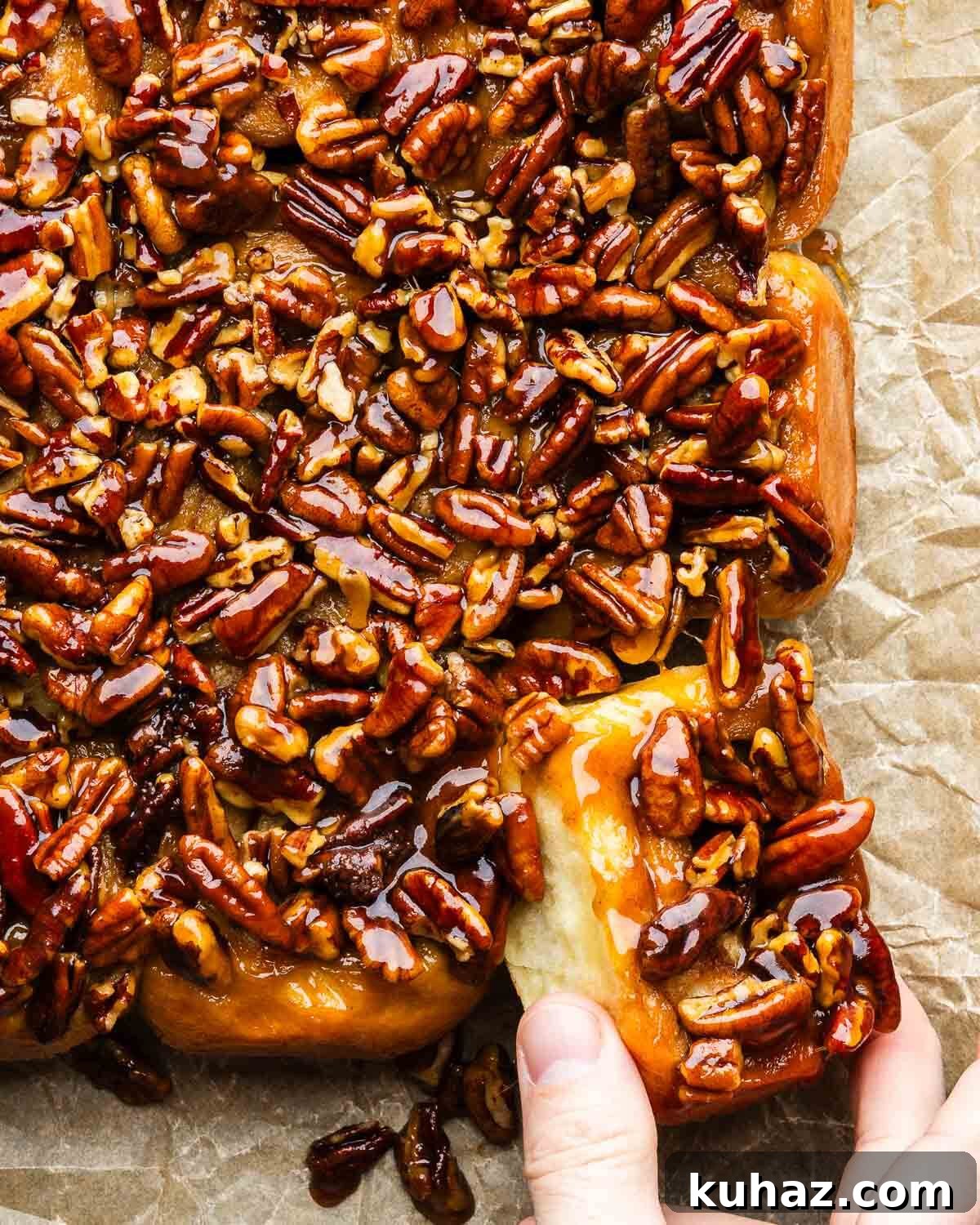 Homemade Gooey Sticky Buns Recipe from Scratch 2 Fingers pulling a sticky bun from bunch of buns.