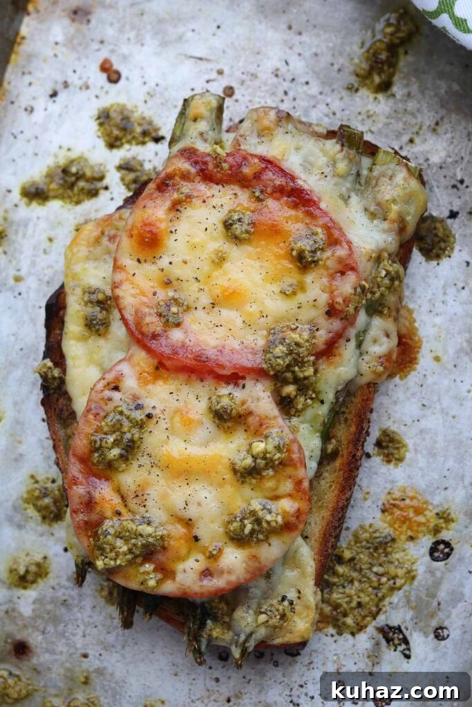 Roasted Asparagus and Tomato Pesto Melt Recipe 2 roasted asparagus tomato pesto melt on baking sheet with pesto drizzle