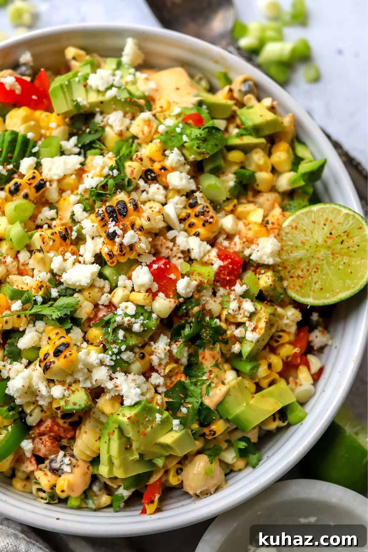 Up close photo of Mexican Street Corn salad in a bowl with seasonings. 