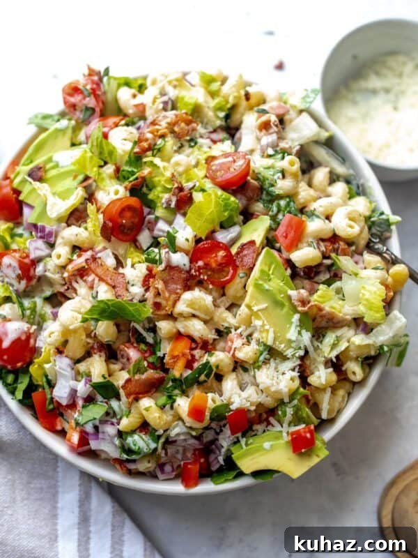 BLT Pasta Salad in a white bowl with a big spoon