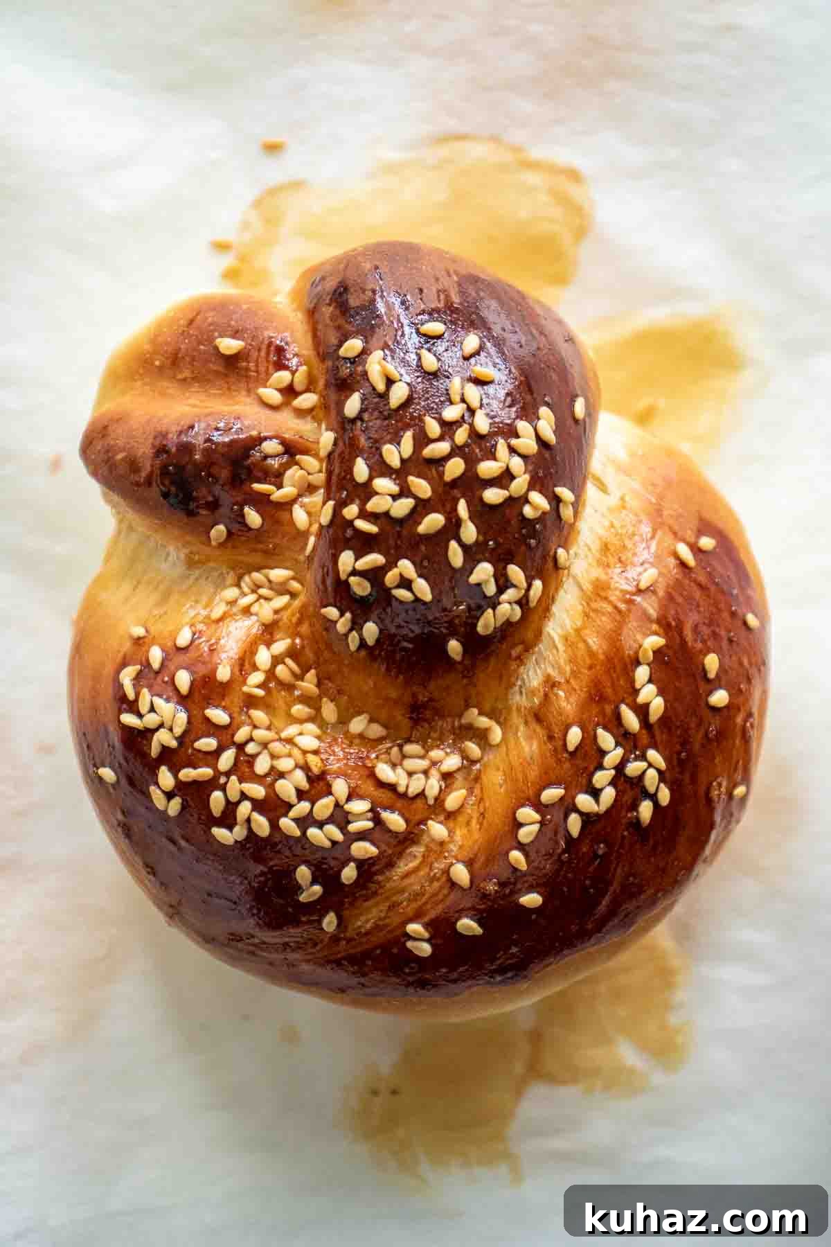 Soft Challah Rolls Recipe for Fluffy Challah Buns 2 A baked challah roll over parchment paper.