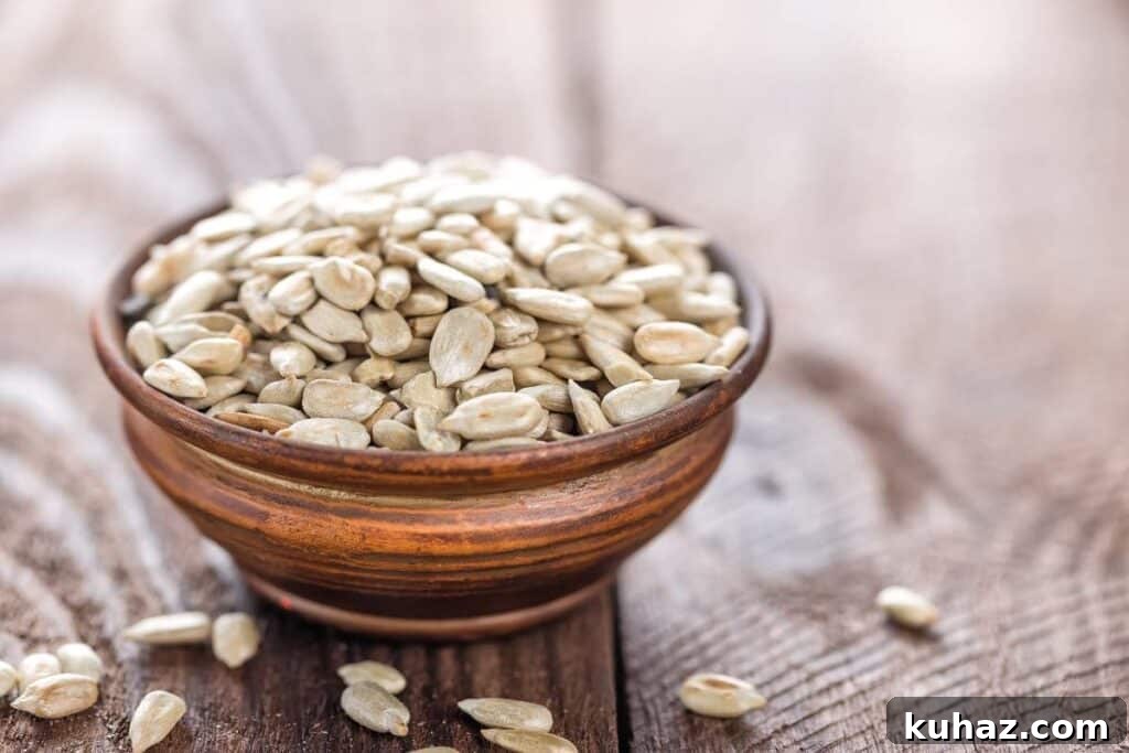 A wooden bowl of sunflower seeds on  a wooden table.
