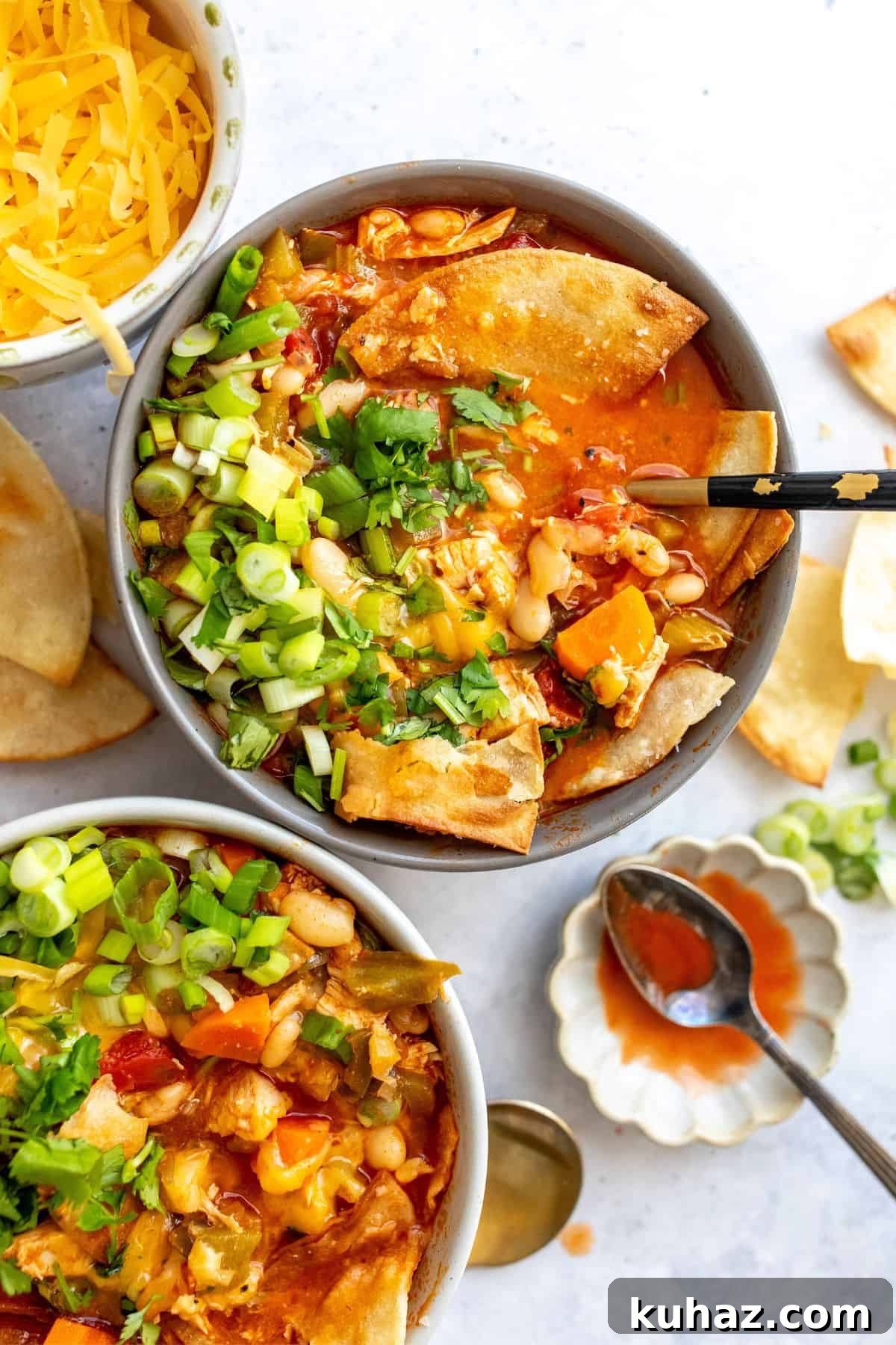 Spicy Buffalo Chicken Chili Recipe 2 Grey ceramic bowl filled with buffalo chicken chili and a black handled spoon.