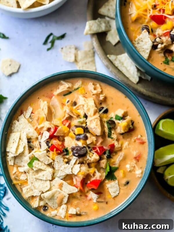 Green bowls with creamy taco soup in them and limes on the side.