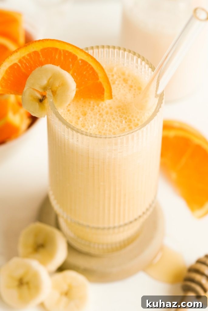 Orange Banana Smoothie Recipe 4 banana and orange banana smoothie in a glass with a glass straw