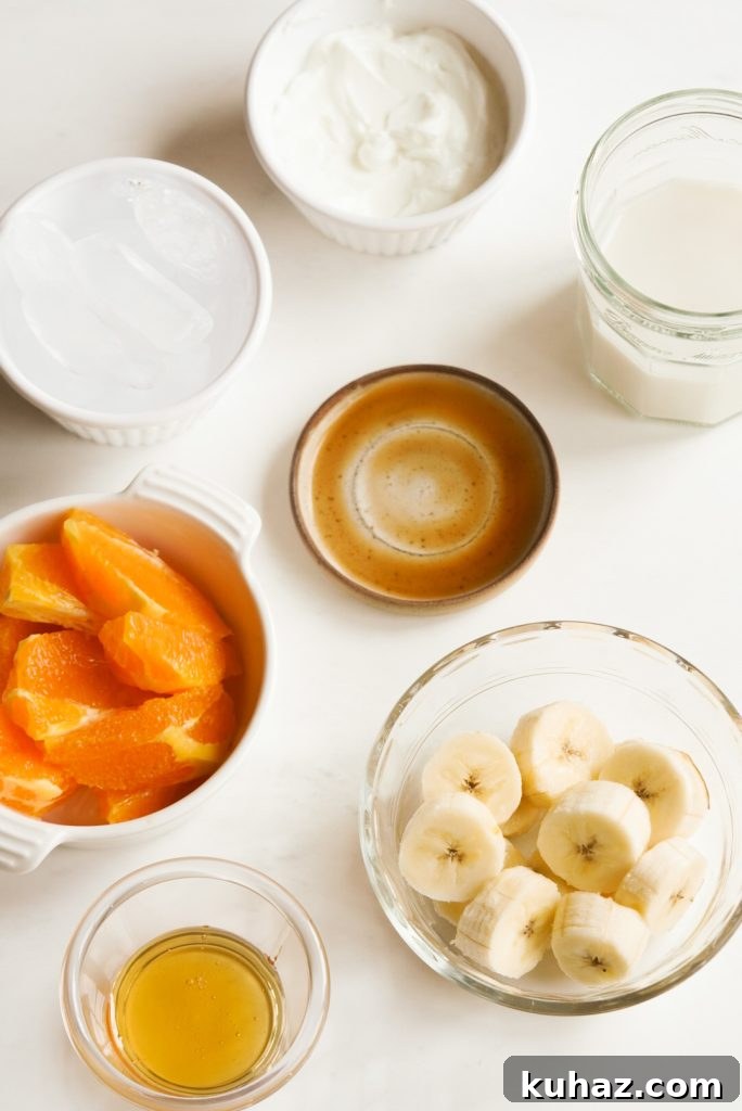 Orange Banana Smoothie Recipe 5 tropical inspired smoothie ingredients measured out on a white table