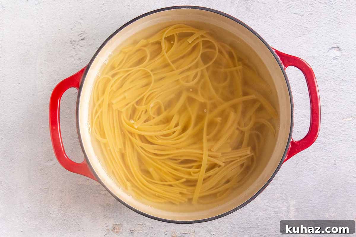 Creamy Avocado Bell Pepper Pasta 4 Top down view of boiled fettuccine noodles in cast iron dutch oven.