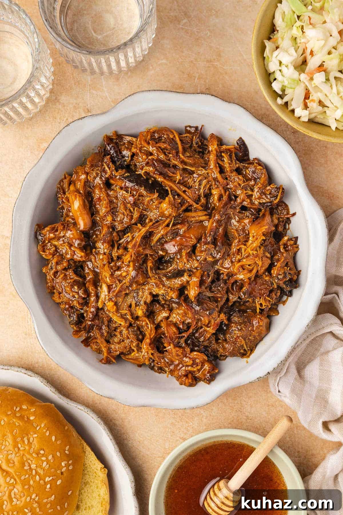 A plate of shredded crockpot slow cooker hot honey chicken thighs.