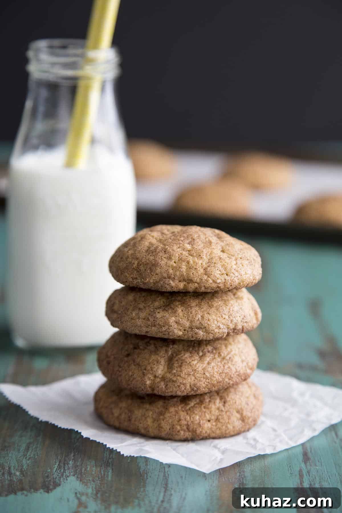 Pumpkin Snickerdoodle Cookies Recipe 5 A stack of pumpkin snickerdoodle cookies with a bottle of milk in the back.