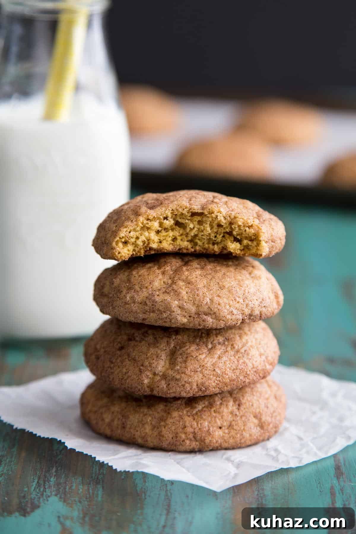 Pumpkin Snickerdoodle Cookies Recipe 6 A stack of pumpkin snickerdoodle cookies with the top one half eaten.