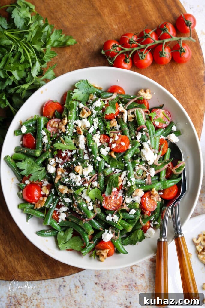 Fresh Green Bean and Tomato Salad with Lemon Vinaigrette 7 cold green bean salad in bowl with ingredients around it.