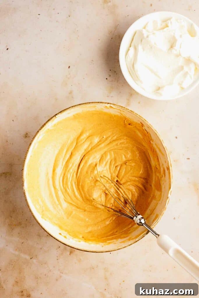 Creamy No-Bake Pumpkin Cheesecake Bars 9 Adding pumpkin to cheesecake filling