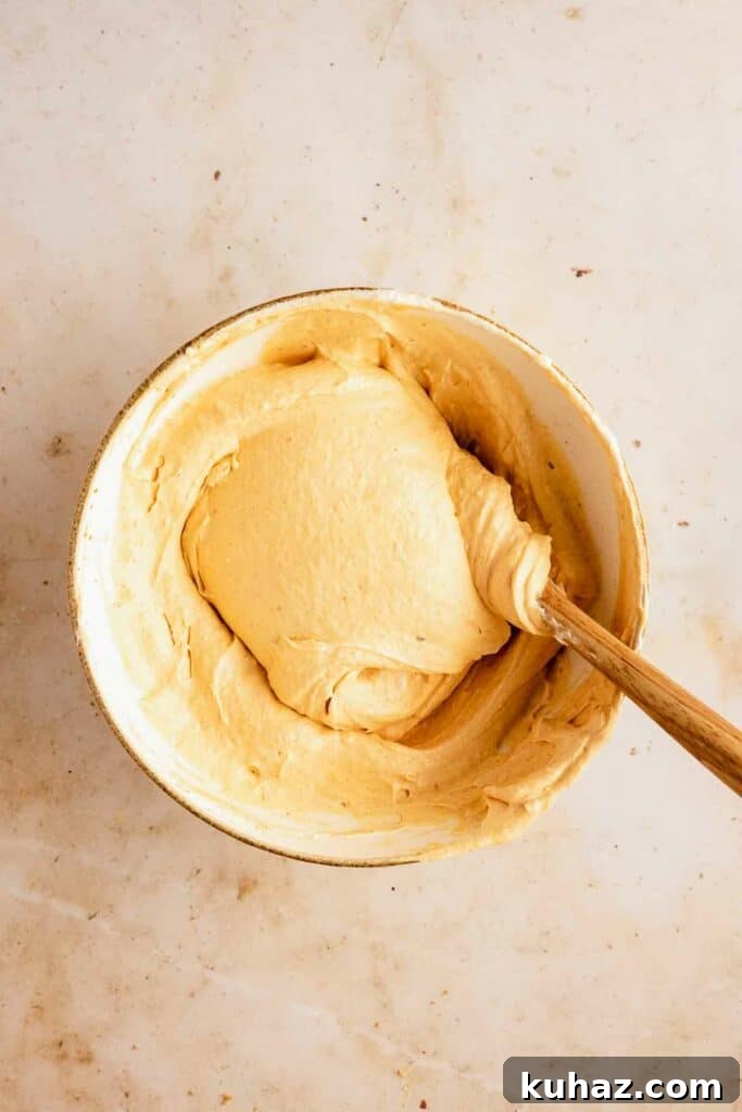 Creamy No-Bake Pumpkin Cheesecake Bars 10 Folding cream into the batter