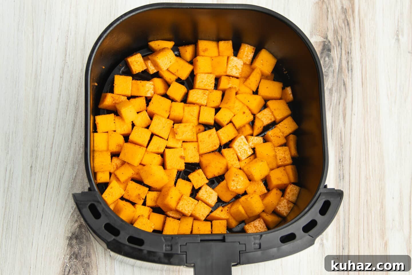 This is a picture raw butternut squash in the air fryer before cooking.