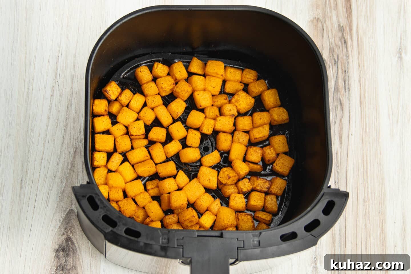 This is a picture of butternut squash in the air fryer after cooking.
