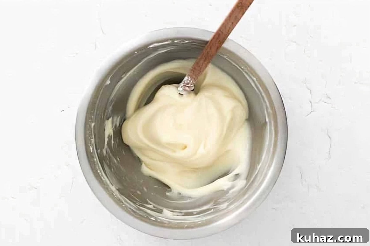 Valentine's Day Macarons: Romantic Recipes and Decorating Ideas 5 macaron batter in a stainless mixing bowl with a rubber spatula.