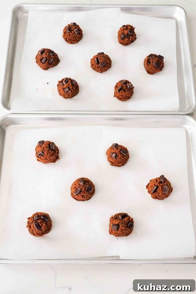 Chewy Double Chocolate Chip Cookies Recipe 12 Unbaked double chocolate chip cookie dough balls on a baking sheet.