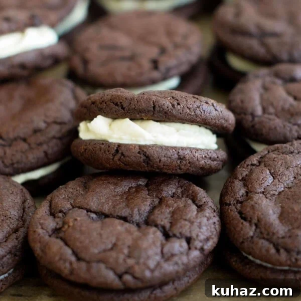 Homemade oreo sourdough cookies sitting in a pile on a baking sheet.