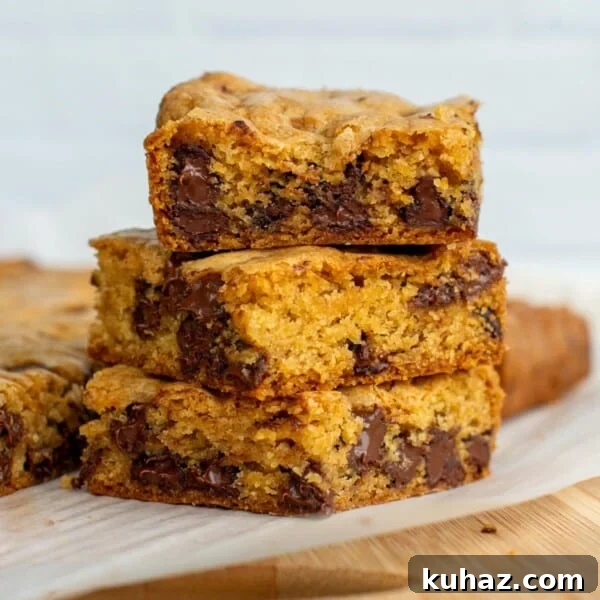 Sourdough Chocolate Chip Cookie Bars stacked on top of each other on parchment paper.