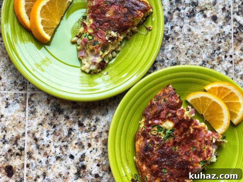 Corn and Gruyere Frittata with Canadian Bacon (4 WW Points) 3 A picture of two slices of the frittata on two green plates, with slices of orange