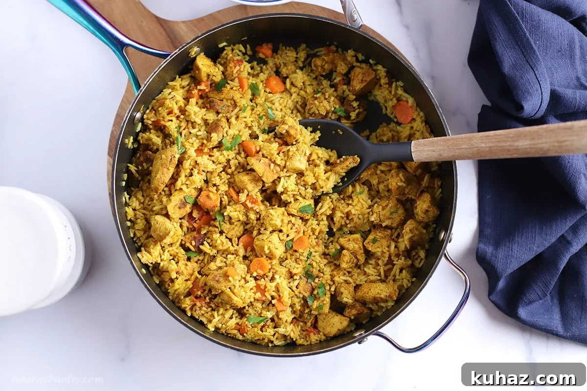 Moroccan Chicken with Saffron Rice 5 An overhead image of a large skillet with yellow rice and chicken.