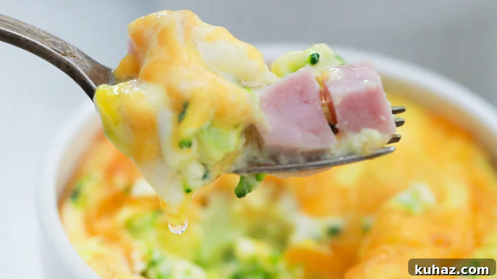 13 Gluten-Free Breakfast Recipes to Kickstart Your Morning 12 A fork holding a bite of mini frittata with ham and broccoli, with the dish in the background.