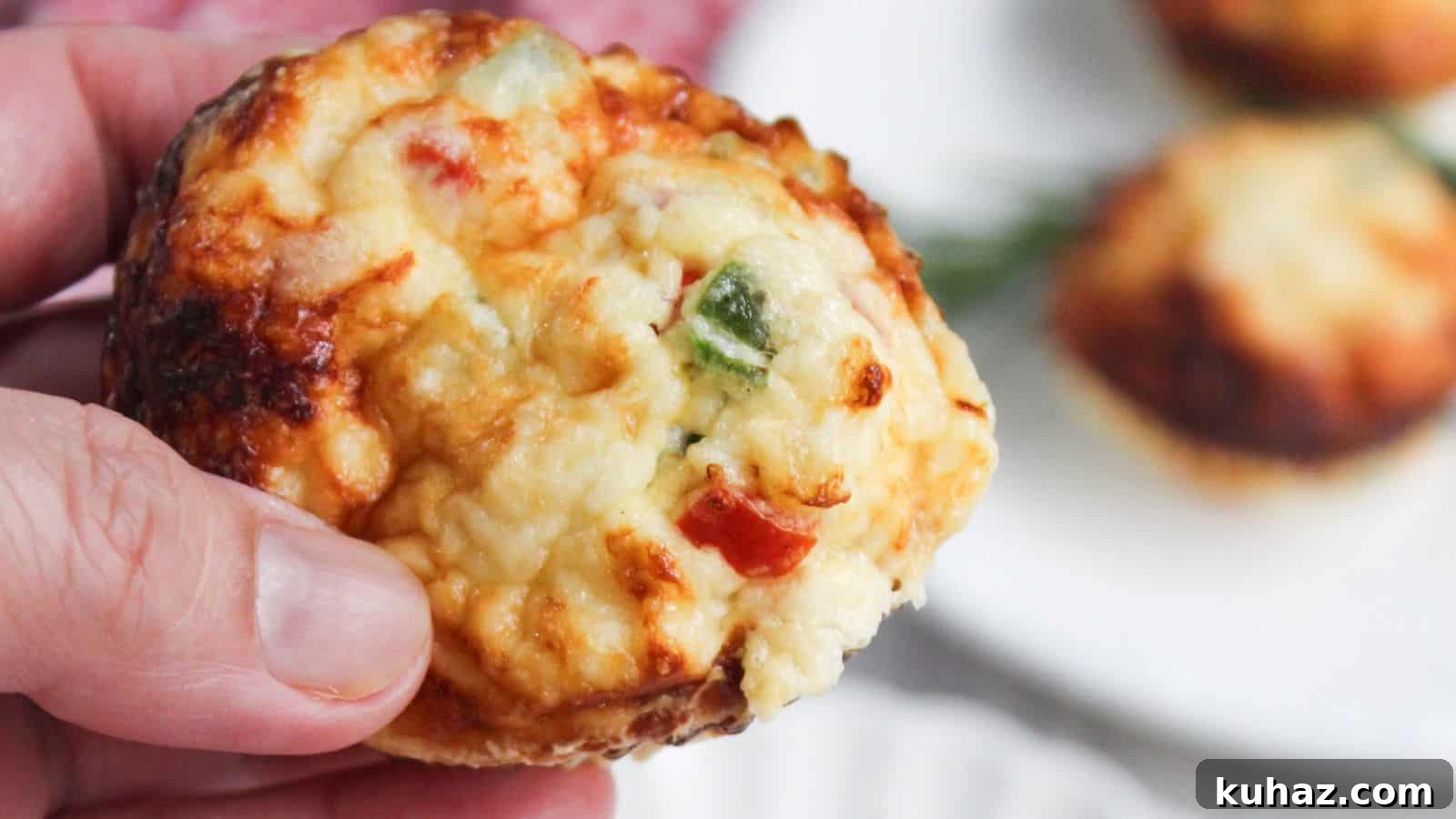 13 Gluten-Free Breakfast Recipes to Kickstart Your Morning 3 A close-up of a hand holding an egg white frittata muffin with visible toppings of cheese and chopped peppers.