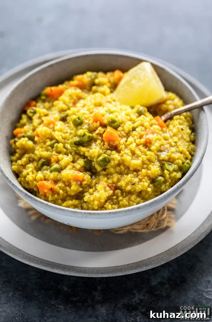 Instant Pot Vegetable Daliya Recipe (Broken Wheat Khichdi) 6 vegetable daliya in a bowl with a side of lemon wedge