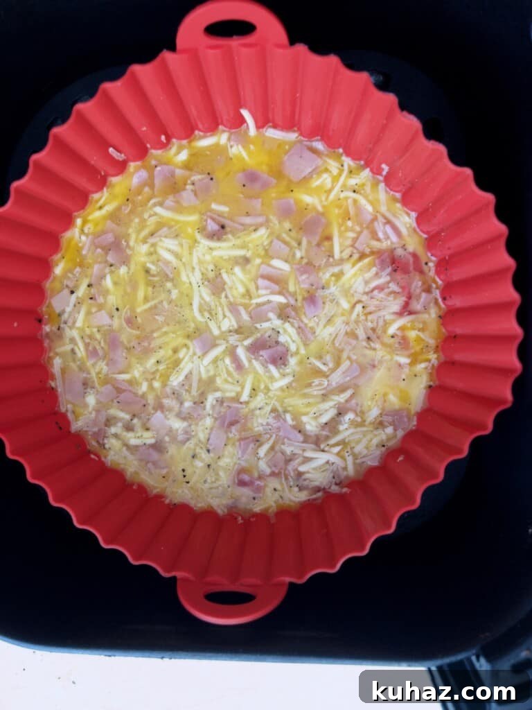 Air Fryer Ham and Cheese Omelet 6 Air fryer ham and cheese omelette in air fryer basket ready to be cooked