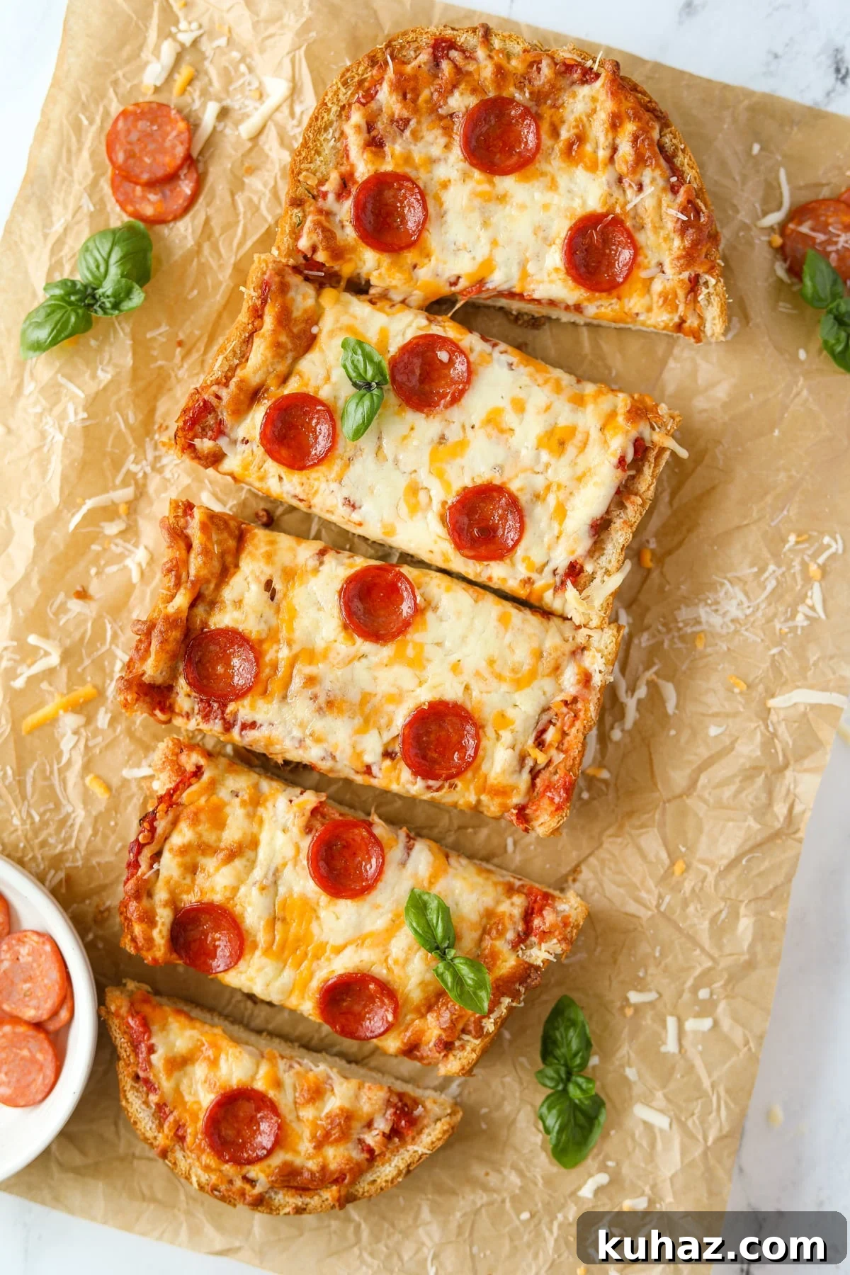 Homemade French Bread Pizza Recipe 12 Half of a loaf of French bread pizza on a sheet of parchment paper.