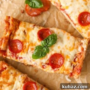 Homemade French Bread Pizza Recipe 13 A rectangular slice of pizza topped with pepperoni and basil.