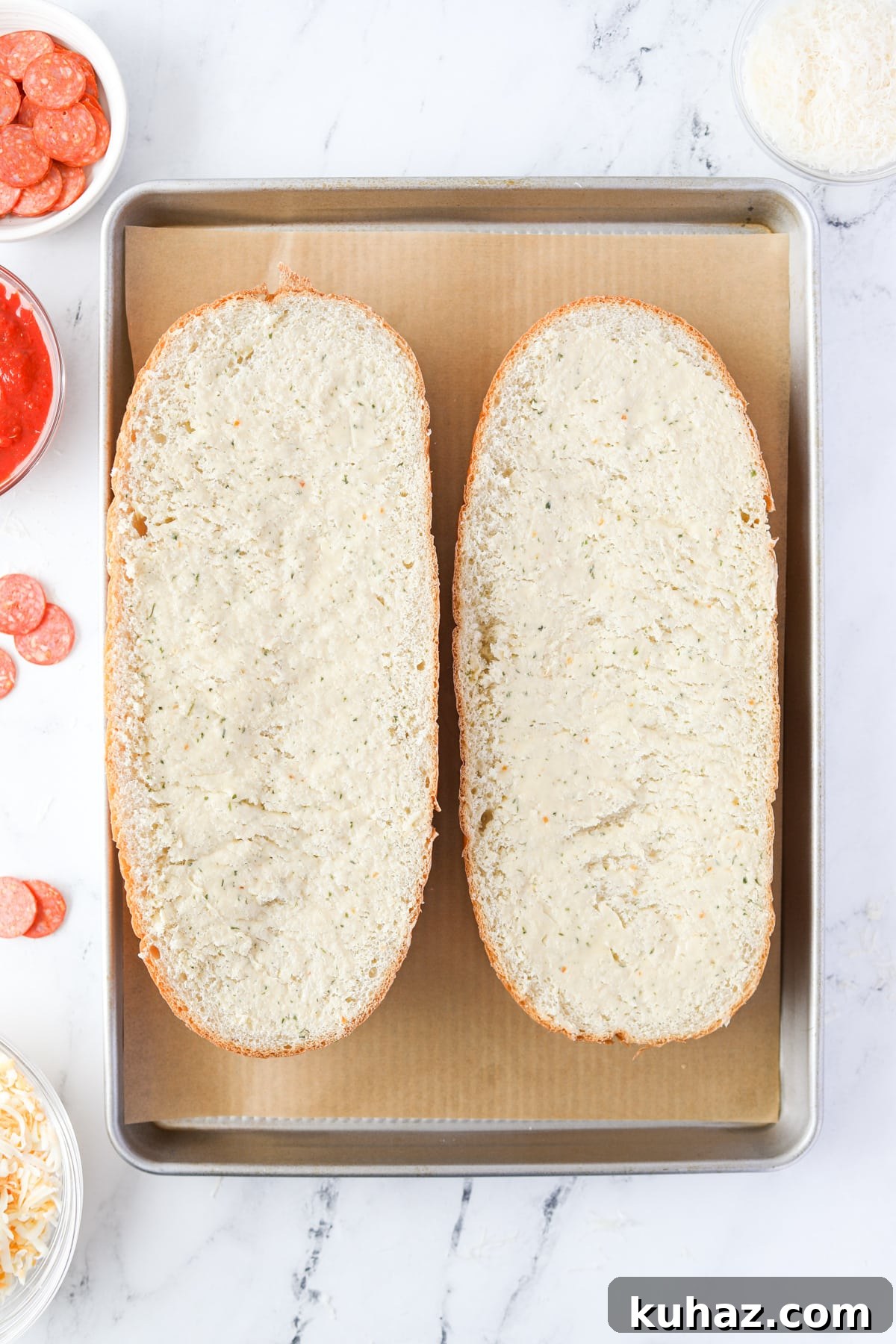 Homemade French Bread Pizza Recipe 4 Two halves of a French Loaf on a baking pan.